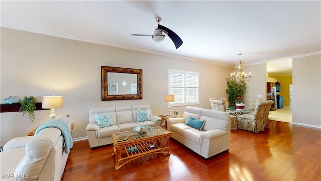 living room featuring baseboards, dark wood-style flooring, ceiling fan with notable chandelier, and crown molding