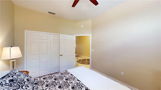 bedroom with a ceiling fan, baseboards, visible vents, and a closet