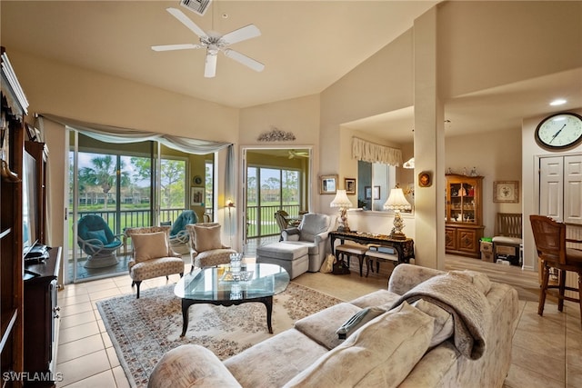 living area with visible vents, high vaulted ceiling, light tile patterned floors, and a ceiling fan