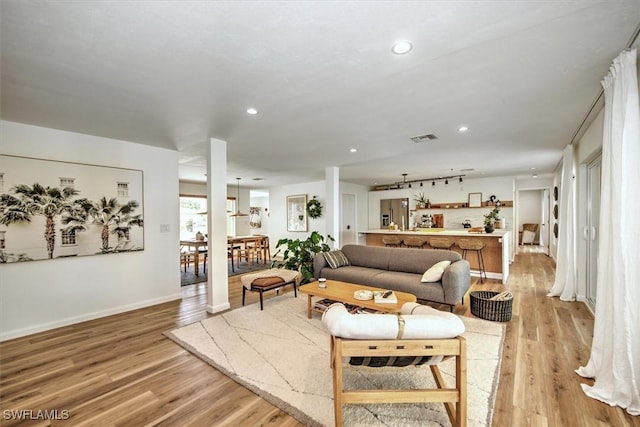 living area featuring baseboards, recessed lighting, visible vents, and light wood-style floors