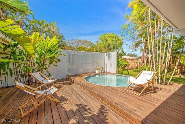 wooden terrace featuring a fenced backyard and a fenced in pool