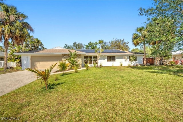 ranch-style house featuring driveway, a front yard, fence, and roof mounted solar panels