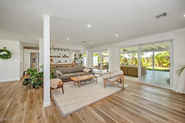 living area featuring light wood finished floors, baseboards, visible vents, and recessed lighting