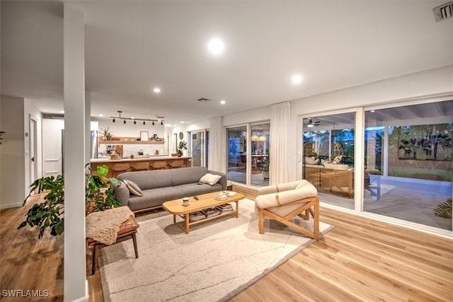 living room featuring visible vents, light wood-style flooring, and recessed lighting