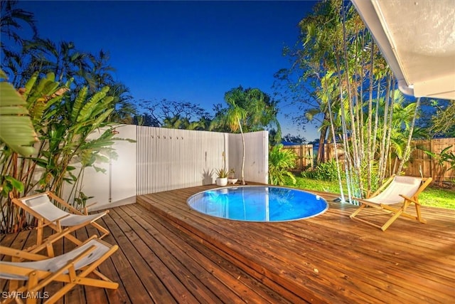 view of swimming pool with a deck, a fenced backyard, and a fenced in pool