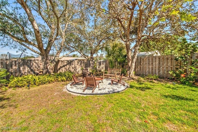 view of yard featuring a fenced backyard and a fire pit