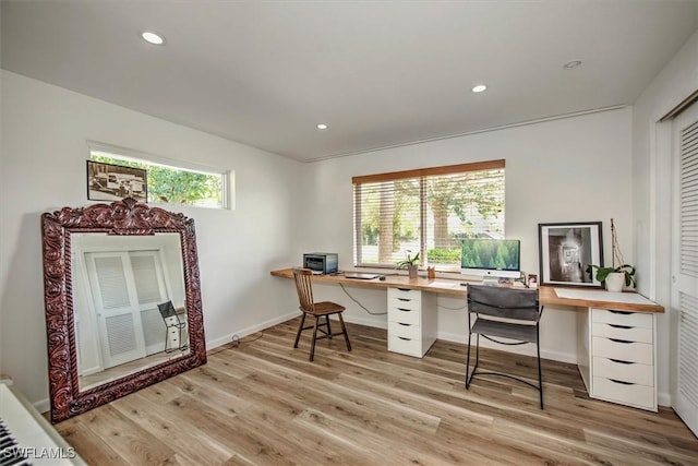 office space featuring baseboards, light wood-type flooring, and recessed lighting