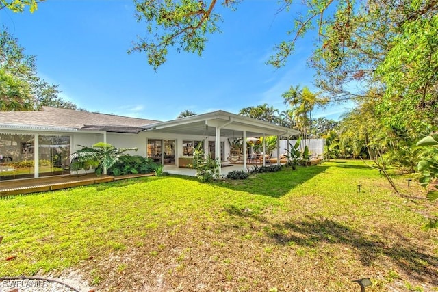 rear view of property featuring a lawn and a patio area