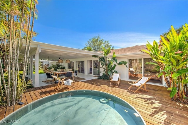 view of swimming pool featuring outdoor dining area, a wooden deck, and a ceiling fan