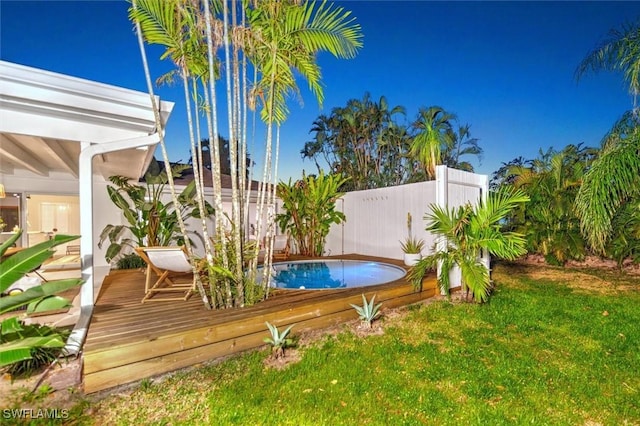 view of yard with a fenced in pool, fence, and a deck