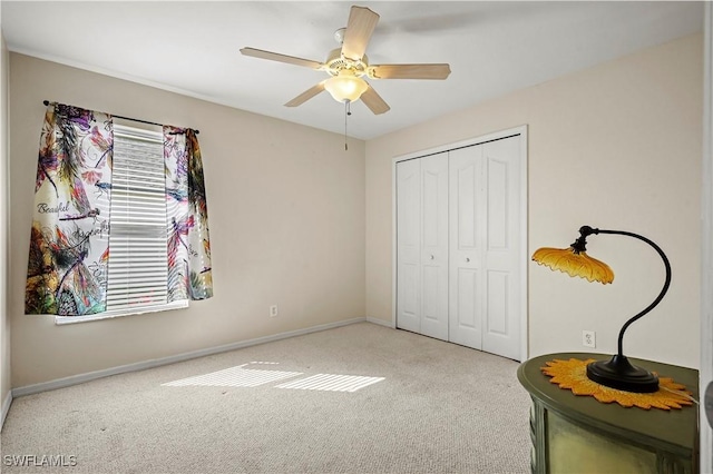 bedroom featuring a closet, light carpet, ceiling fan, and baseboards