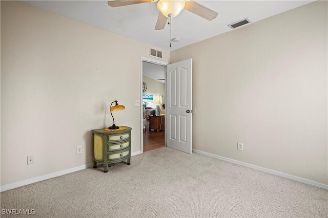 empty room featuring light carpet, baseboards, visible vents, and a ceiling fan