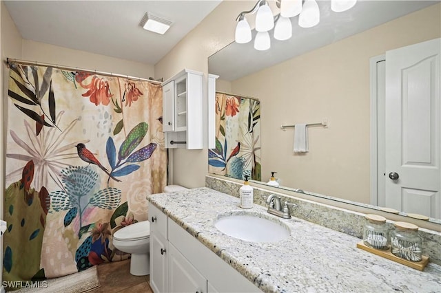 bathroom featuring visible vents, toilet, and vanity