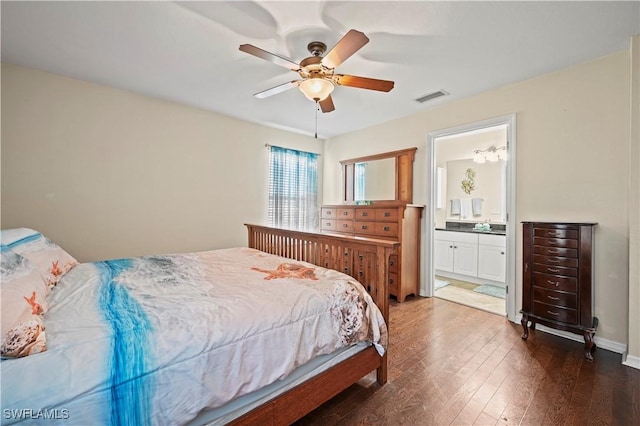 bedroom with dark wood-style flooring, ensuite bath, visible vents, and a ceiling fan