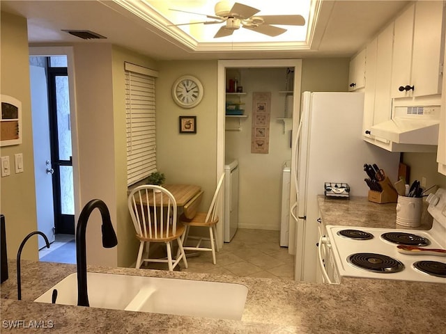 kitchen featuring washing machine and dryer, under cabinet range hood, a sink, white cabinetry, and white range with electric stovetop