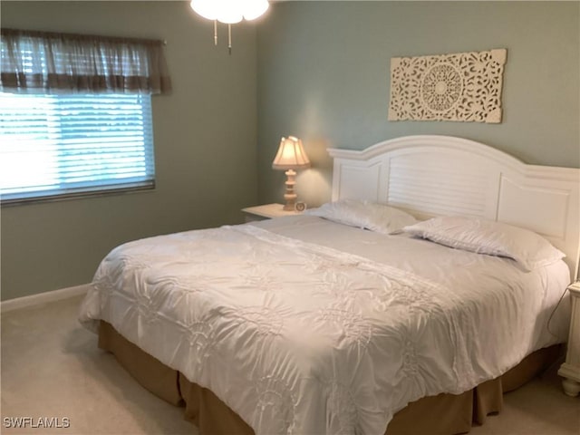 bedroom featuring light colored carpet and baseboards