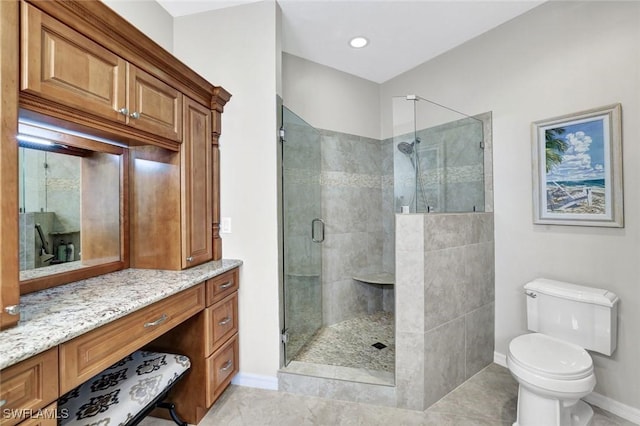 bathroom with baseboards, a shower stall, toilet, and vanity