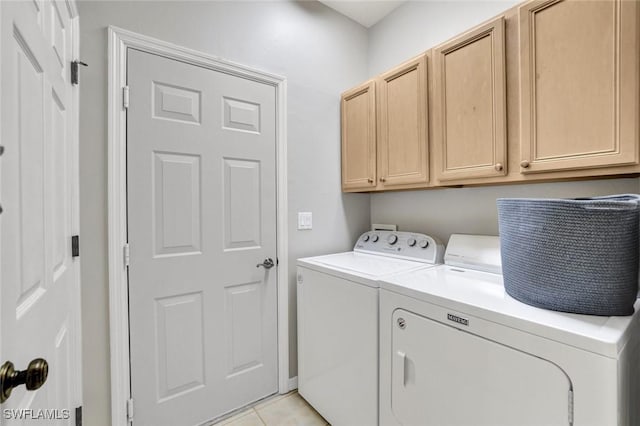 washroom featuring light tile patterned flooring, cabinet space, and separate washer and dryer