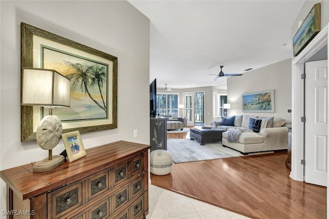 living area featuring light tile patterned floors and ceiling fan