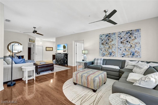 living room with baseboards, ceiling fan, visible vents, and wood finished floors