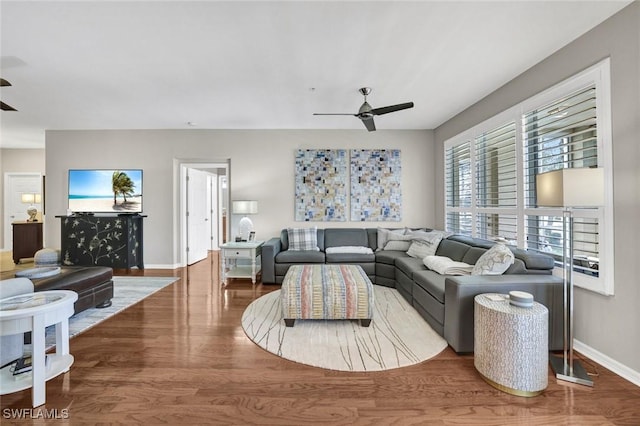 living room featuring ceiling fan, wood finished floors, and baseboards