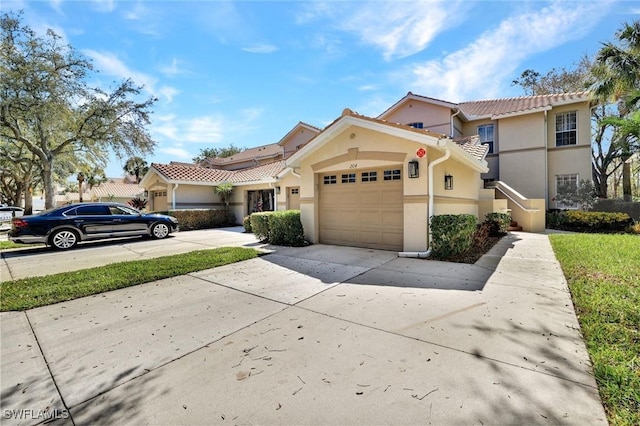 view of front of property featuring a garage, driveway, a tiled roof, and stucco siding