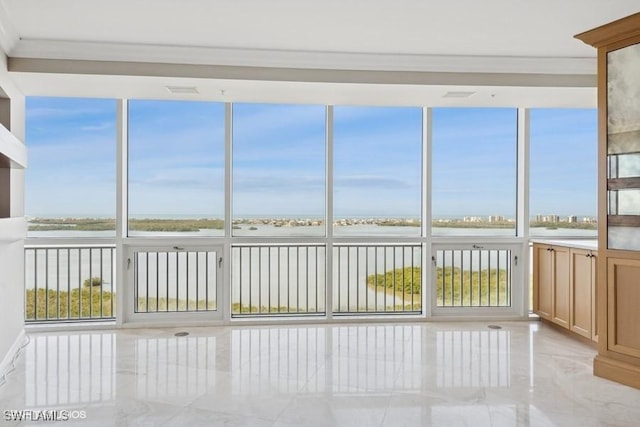 unfurnished sunroom featuring a water view