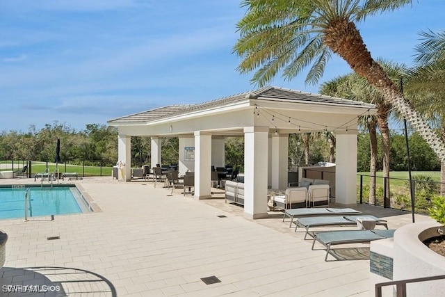 community pool with fence and a gazebo