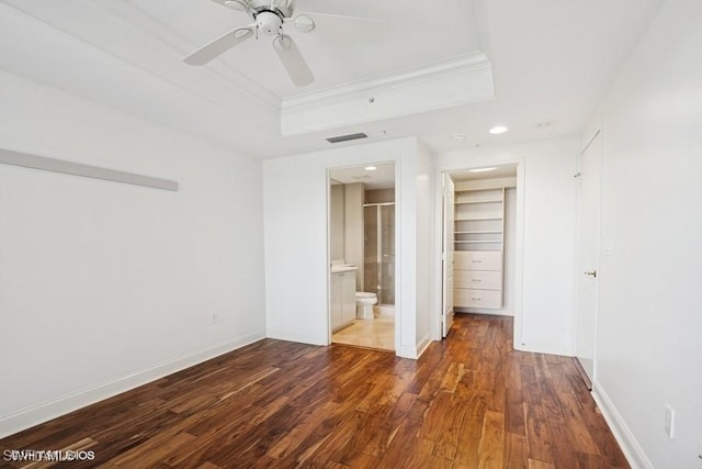 empty room featuring wood finished floors, a raised ceiling, visible vents, and baseboards