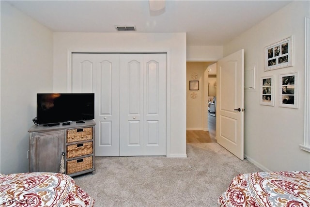 bedroom featuring arched walkways, light carpet, visible vents, baseboards, and a closet