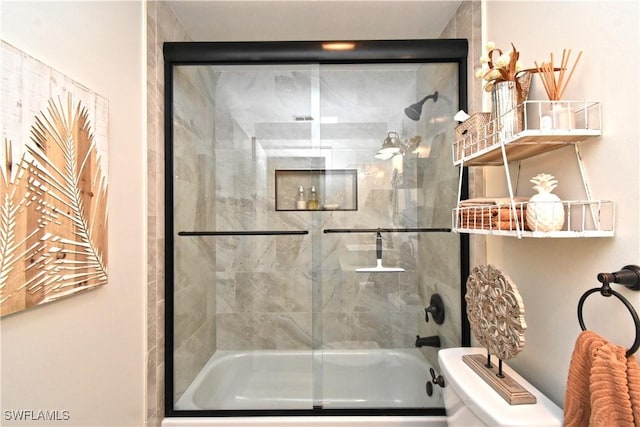 bathroom featuring shower / bath combination with glass door and toilet