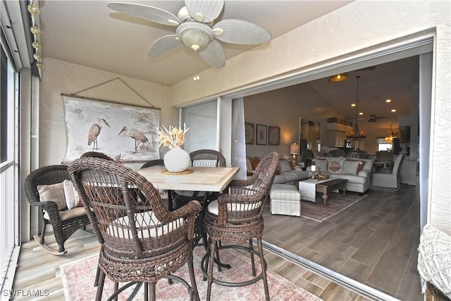 dining room with a textured wall, wood finish floors, and a ceiling fan