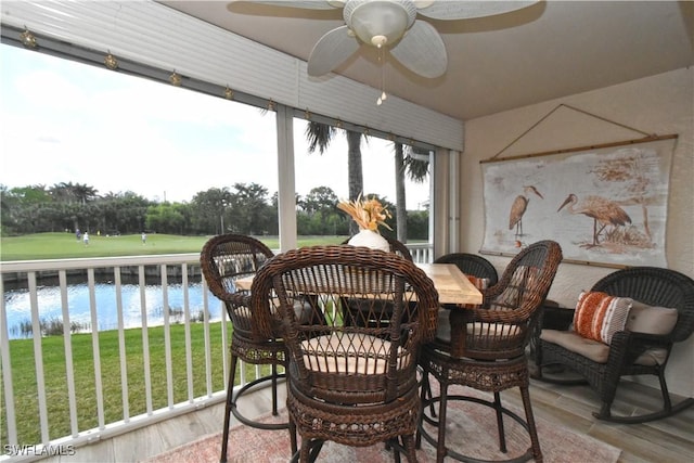 sunroom with a water view and ceiling fan