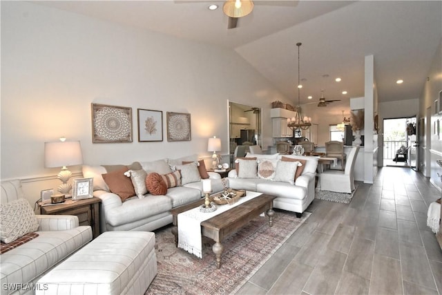 living area with a ceiling fan, high vaulted ceiling, and wood finished floors