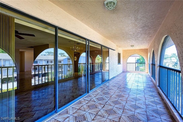 corridor featuring a textured ceiling and a textured wall