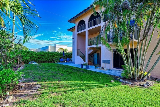 view of yard with a patio and a balcony