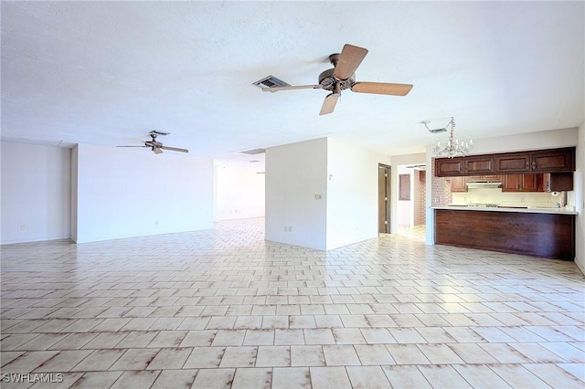 unfurnished living room featuring ceiling fan, a textured ceiling, light tile patterned flooring, and visible vents