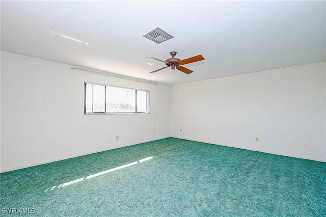 spare room with a ceiling fan, visible vents, and carpet flooring