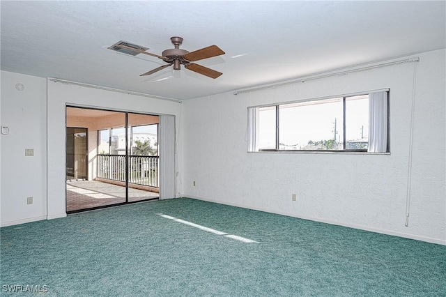 carpeted spare room with a ceiling fan, visible vents, and a textured wall