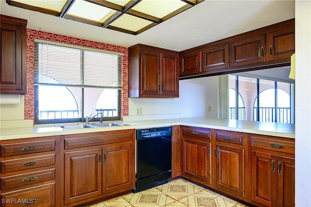 kitchen featuring black dishwasher, a peninsula, light countertops, light floors, and a sink