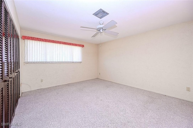 unfurnished room featuring carpet, ceiling fan, and visible vents