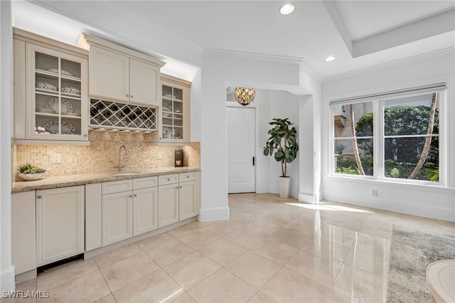 kitchen with glass insert cabinets, decorative backsplash, and a sink