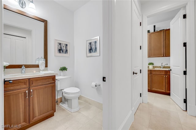 bathroom with two vanities, a sink, and toilet