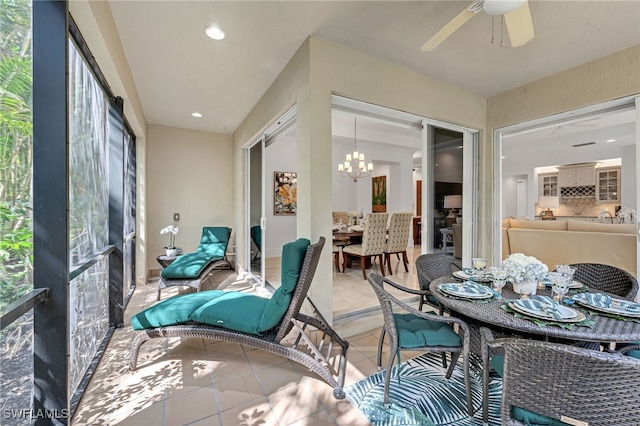 sunroom with ceiling fan with notable chandelier