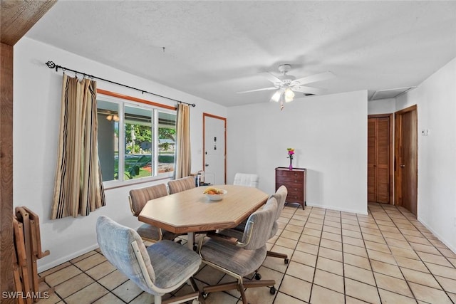 dining area featuring baseboards, radiator, ceiling fan, a textured ceiling, and light tile patterned flooring