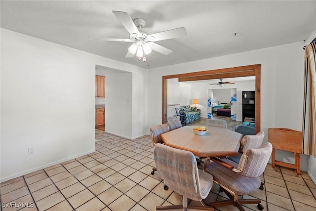 dining room with light tile patterned floors, a ceiling fan, and baseboards