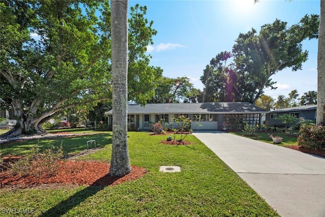 ranch-style home with concrete driveway and a front yard