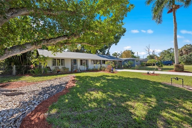 ranch-style home with a front lawn and fence