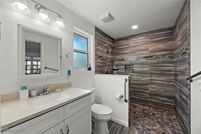 full bath with visible vents, vanity, toilet, and walk in shower