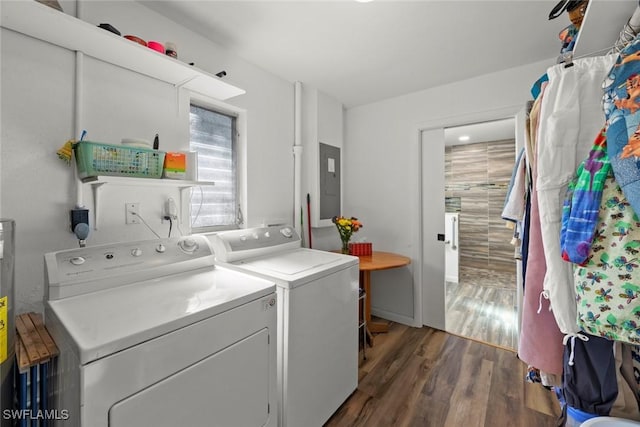 washroom featuring laundry area, electric panel, wood finished floors, and independent washer and dryer